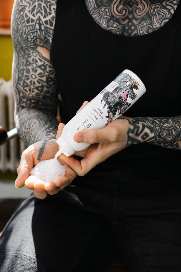 tatuerad man sprutar ut prep: hand sanitizer mousse i hans hand