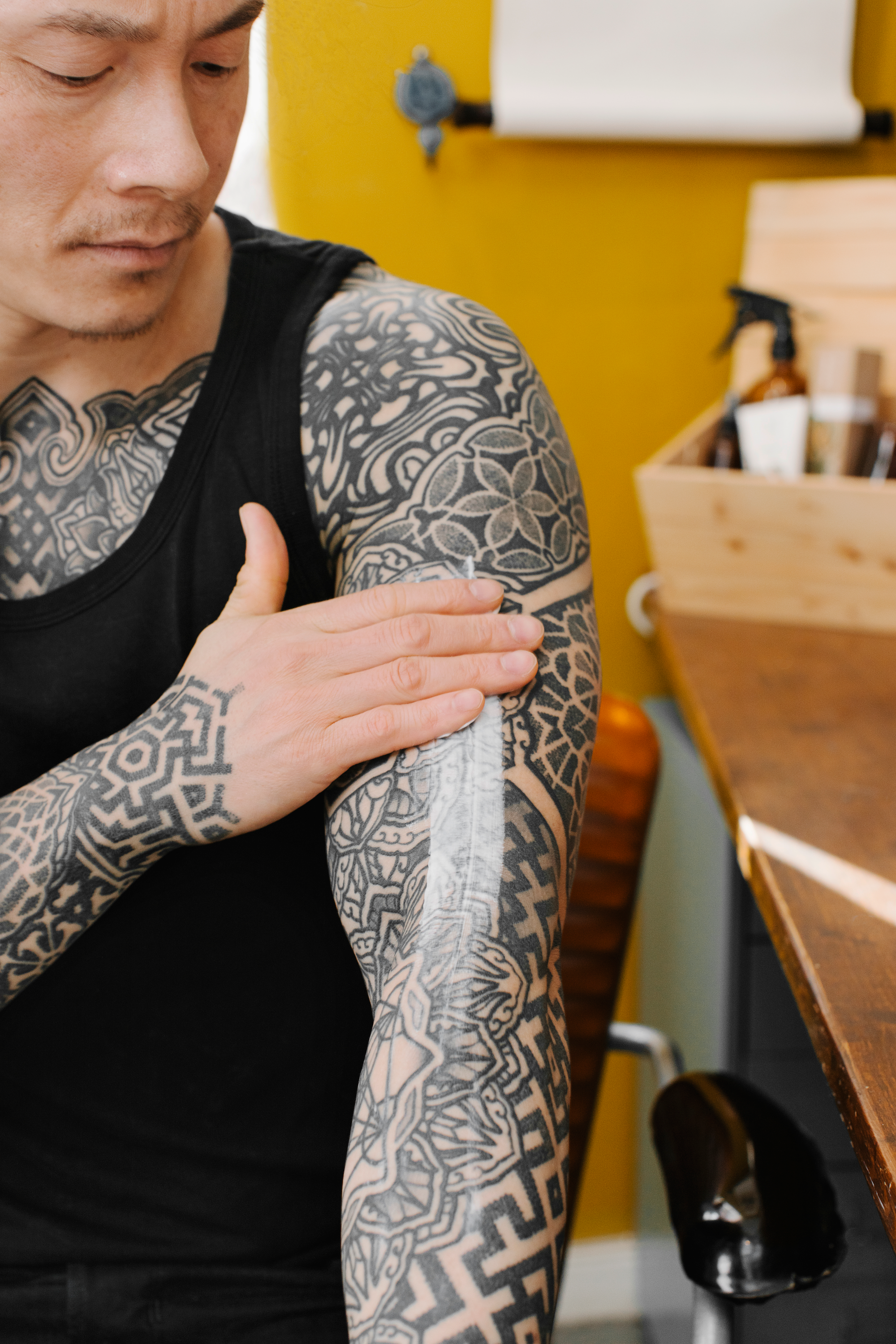 man som applicerar tatueringskräm på armen